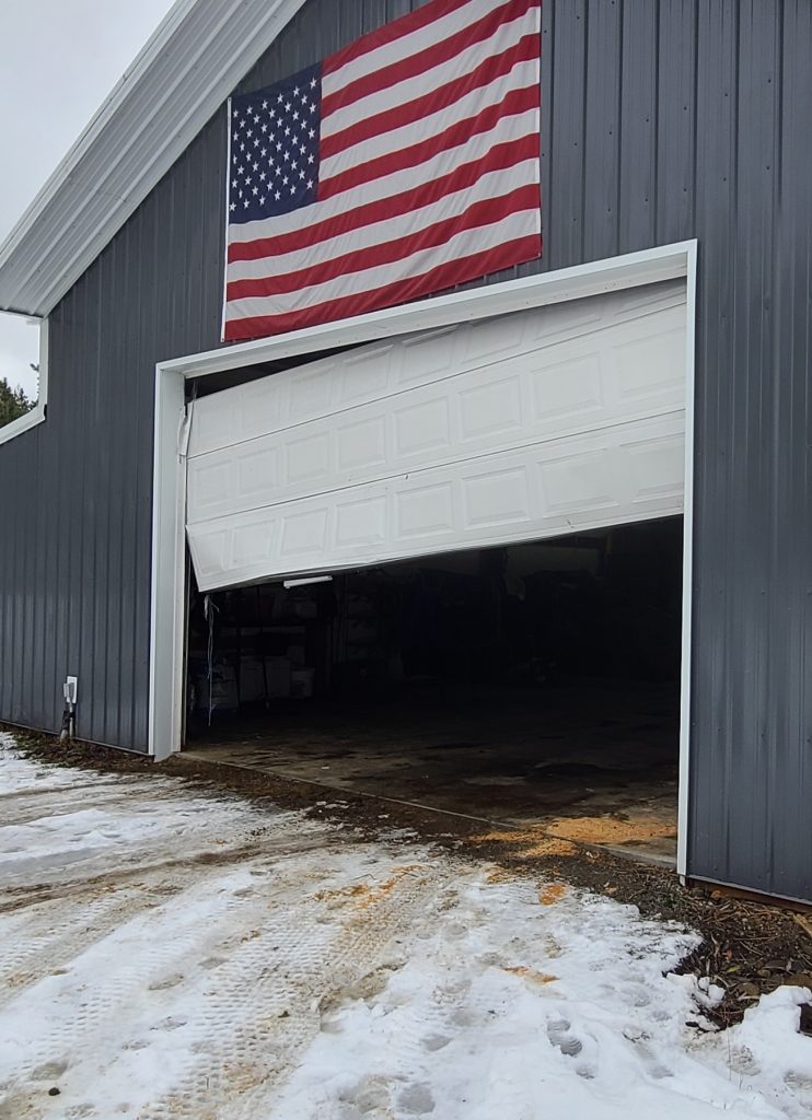 broken garage door and American flag
